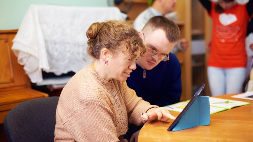 Zwei Menschen mit Behinderung arbeiten am Tablet